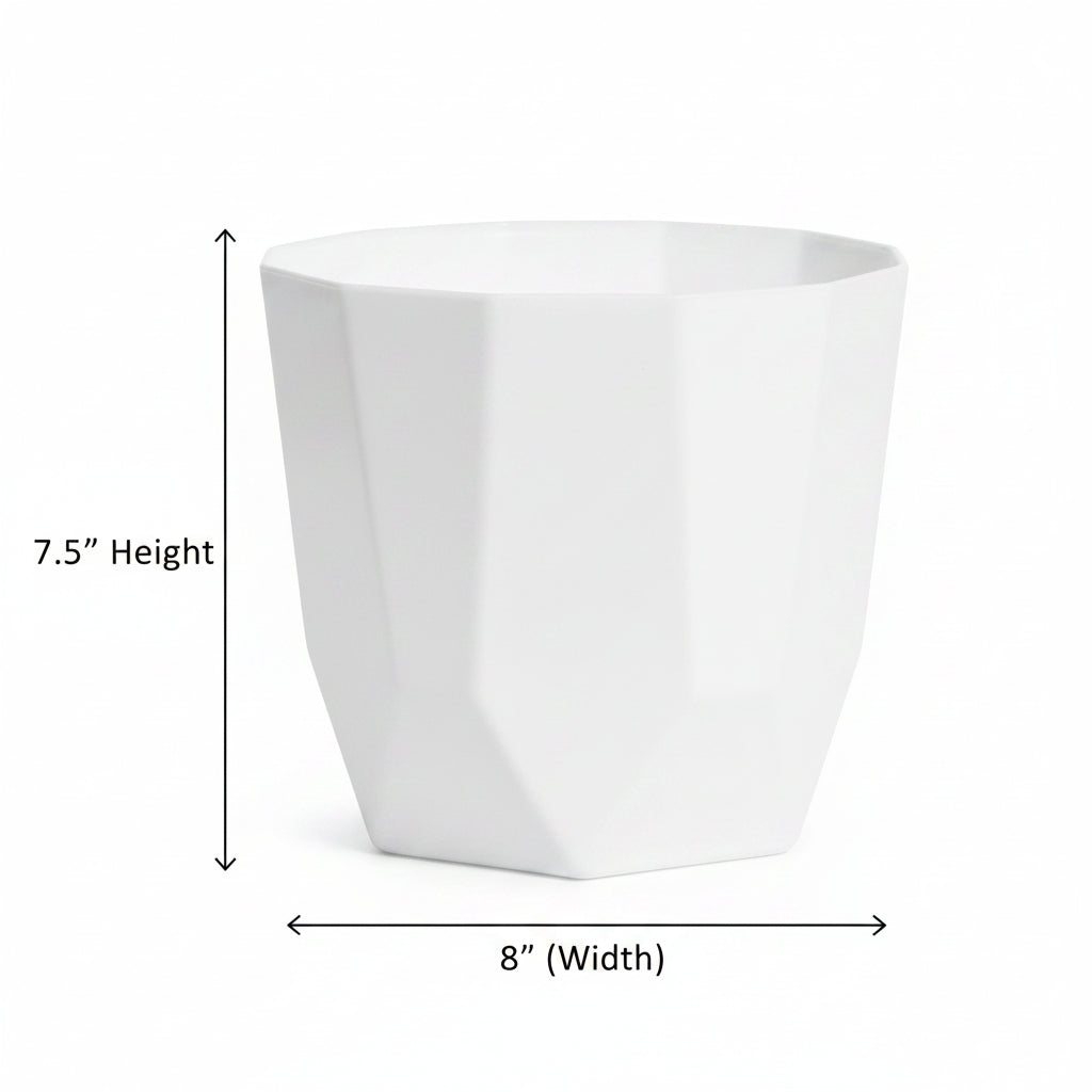 A white faceted geometric planter pot displayed on a wooden stool against a plain beige wall.